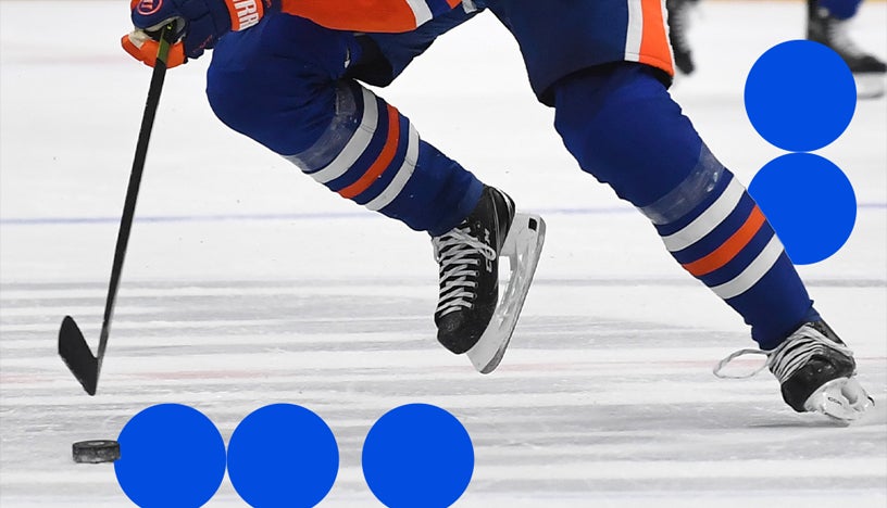 Close up shot of hockey player skating on ice passing puck